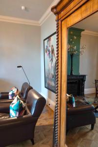a mirror in a living room with a couch and a fireplace at Hotel Villa Trompenberg in Hilversum