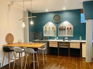 a kitchen with a table and a clock on the wall at Terrasses de Saint Pierre - Papyrus in Saint-Pierre