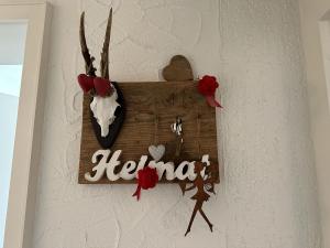 a sign that says hello on a wall with red roses at Haus Albi in Waldkirch
