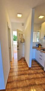 a kitchen with white cabinets and a wooden floor at Apartamento 203 Castell Sol CB in Arenal d'en Castell