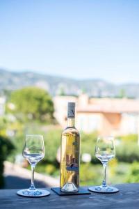 twee wijnglazen en een fles op tafel bij The Cap - Charming apartment in Saint-Jean-Cap-Ferrat