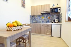 una cocina con mesa y un bol de fruta en Acunto's Homes, en Agerola