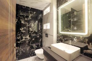 a black and white bathroom with a sink and a mirror at OPO Hotels D'or in New Delhi