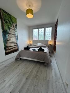 a bedroom with a bed and a painting on the wall at Le Pragmatique - Paris Parc Expo, logement entier in Vanves