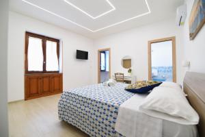 1 dormitorio con 1 cama con manta azul y blanca en Acunto's Homes, en Agerola