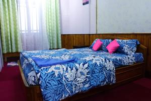 a bedroom with a bed with blue and pink pillows at Darjeeling Homes in Darjeeling