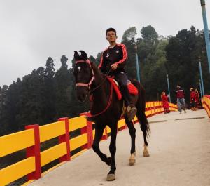 un hombre está montando un caballo en un puente en Himali Homestay , Mirik, en Mirik