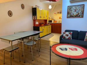 - un salon avec une table, des chaises et un canapé dans l'établissement Spacieux Studio Seventies: voyage dans le temps, à Gannat