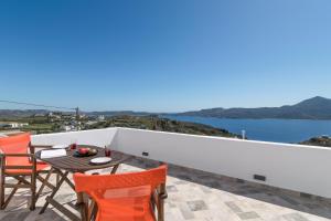 a balcony with a table and chairs and a view of the ocean at Noula House & Studios in Plaka Milou