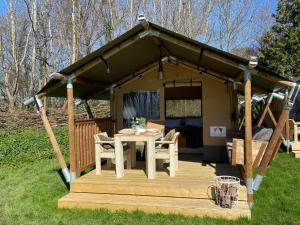 a gazebo with a table on a deck at Camping Zee van Tijd Holwerd in Holwerd +17 photos