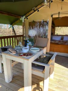 einen Tisch mit Teller mit Essen auf einer Veranda in der Unterkunft Camping Zee van Tijd Holwerd in Holwerd