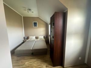 a bedroom with a bed and a wooden cabinet at Apartament USTKA in Ustka