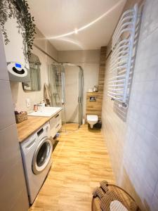 a bathroom with a washing machine and a sink at Apartament USTKA in Ustka