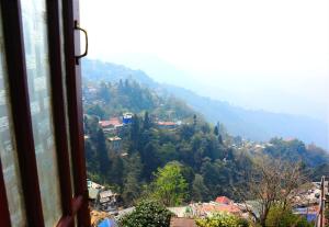 a view from a window of a mountain at Darjeeling Homes in Darjeeling
