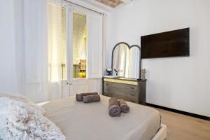 ein Schlafzimmer mit einem Bett mit zwei Hausschuhen darauf in der Unterkunft Hauzify I Novavila Centre Rooms in Vilanova i la Geltrú
