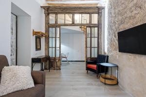 a living room with a couch and a tv on a wall at Hauzify I Novavila Centre Rooms in Vilanova i la Geltrú