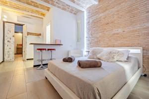 una camera con letto e muro di mattoni di Hauzify I Novavila Centre Rooms a Vilanova i la Geltrú