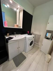 uma casa de banho com um lavatório e uma máquina de lavar roupa em Le Pragmatique - Paris Parc Expo, logement entier em Vanves