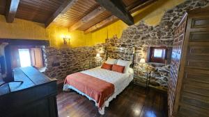 a bedroom with a bed and a stone wall at La Clerecia de Ledesma in Ledesma