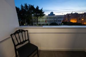 una silla sentada en un balcón con vistas a un edificio en Niki’s Apartments, en Tirana