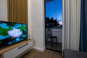 a living room with a television and a chair at Niki’s Apartments in Tirana