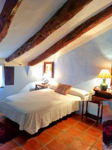 a bedroom with a white bed and two night stands at Masía Finca La Sazadilla con Piscina in Albentosa