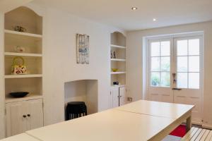 uma cozinha branca com uma mesa e uma janela em Modern & Glamorous Home Brighton Pier Beach SLP16 em Brighton & Hove