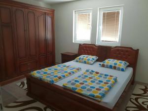 a bedroom with a bed with blue and yellow pillows at Villa ED in Sarajevo
