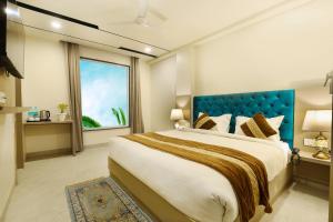 a bedroom with a large bed with a blue headboard at OPO Hotels D'or in New Delhi