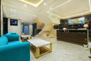 a living room with a blue couch and a tv at OPO Hotels D'or in New Delhi