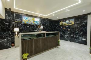 eine Lobby mit einer Theke mit schwarzen Marmorwänden in der Unterkunft OPO Hotels D'or in Neu-Delhi