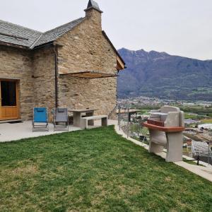 a stone building with chairs and tables on a lawn at Ca'Gialla in Bellinzona