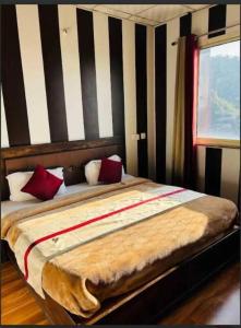 a bedroom with a large bed with red pillows at Hotel Maya Mussoorie - Near Mall Road - Luxury Room - Excellent Customer Service in Mussoorie