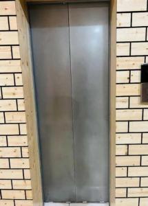 una gran puerta de metal en una pared de ladrillo en Hotel Maya Mussoorie - Near Mall Road - Luxury Room - Excellent Customer Service, en Mussoorie