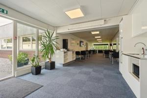 an empty office lobby with tables and chairs at BB-Hotel Herning "Messehotel" in Herning