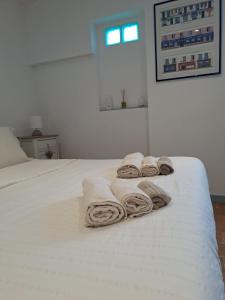 a white bed with three rolled towels on it at Casa Susy in Rome