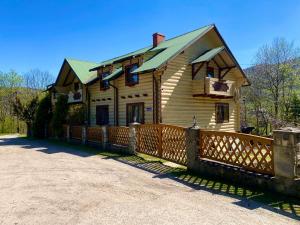 a house with a wooden fence in front of it at Family in Yaremche