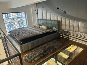 a bedroom with a bed and a large window at The Factory Loft Prague in Prague