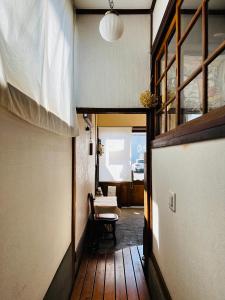 a hallway with a room with a chair and a window at Guesthouse Azumaya in Matsumoto