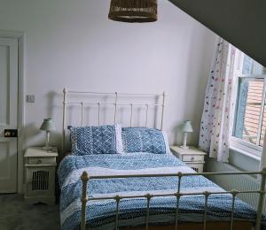 a bedroom with a bed with a blue comforter at City Boho Loft Apartment Free Parking in Brighton & Hove