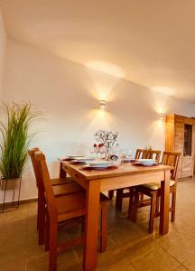 a dining room table with chairs and a wooden tableablish at Casa Elena in Sant Pere Pescador