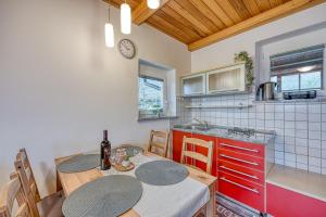 cocina con mesa y sillas y cocina con reloj en Lovely Cottage Tilka - Happy Rentals, en Novo Mesto
