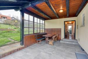 une terrasse avec un plafond en bois, une table et des bancs dans l'établissement Lovely Cottage Tilka - Happy Rentals, à Novo Mesto