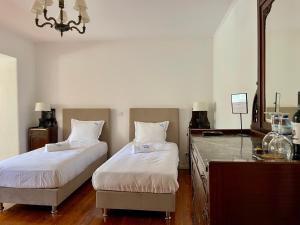 a bedroom with two beds and a dresser and a mirror at Change The World - Solar de Alvega in Alvega