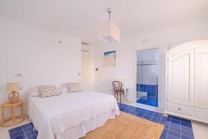 a white bedroom with a bed and a blue tile floor at Casa Giulia in Vieste