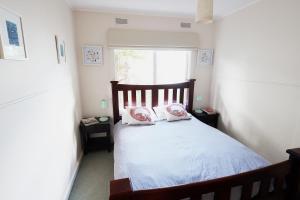 a bedroom with a bed with two pillows on it at Mcrae retro beach house ! in McCrae
