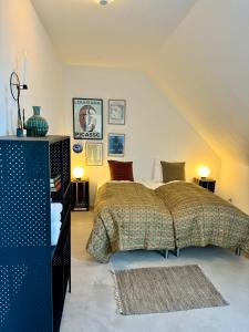 a bedroom with a bed and two tables and two lamps at Ellens Have, Lejlighed Asta in Ebeltoft