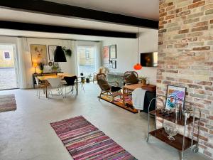 a living room with a brick wall and a table and chairs at Fantastic holiday apartment - Asta in Ebeltoft