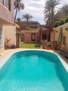 a swimming pool in the yard of a house at Hoppa Guest House Nile View in Luxor