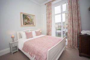 Schlafzimmer mit einem großen Bett und einem Fenster in der Unterkunft Stylish City Centre Apartment - Bath in Bath